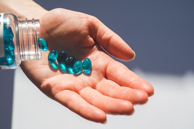 person-holding-blue-pills-4058296